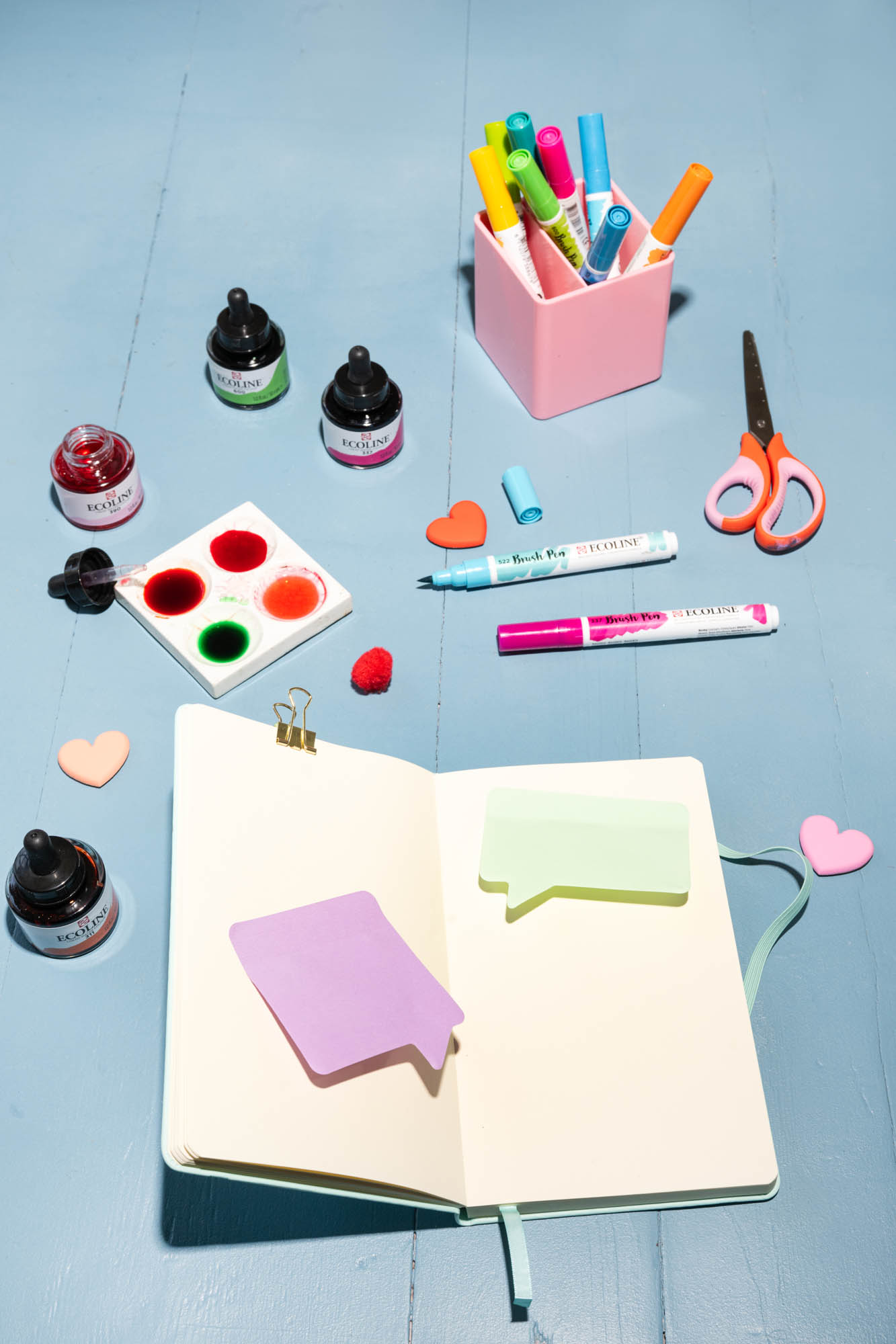 Ecoline inkt, brush pens en notitieboek op blauw