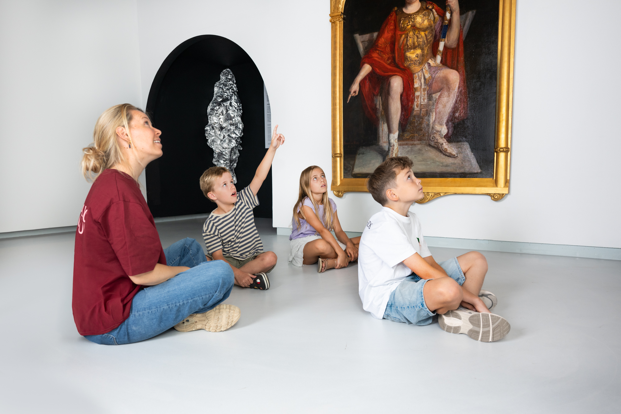 Medewerker met kinderen in de tentoonstellingsruimte