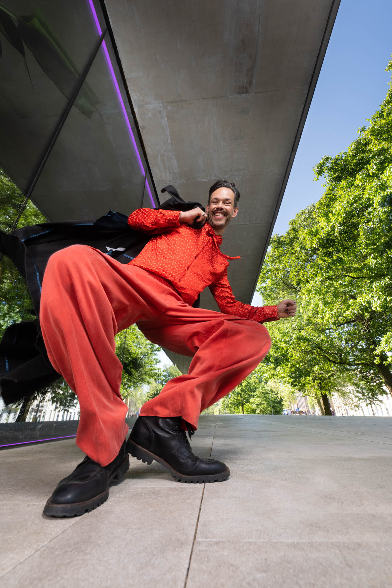 Dansende man in rood voor Musis Stadstheater