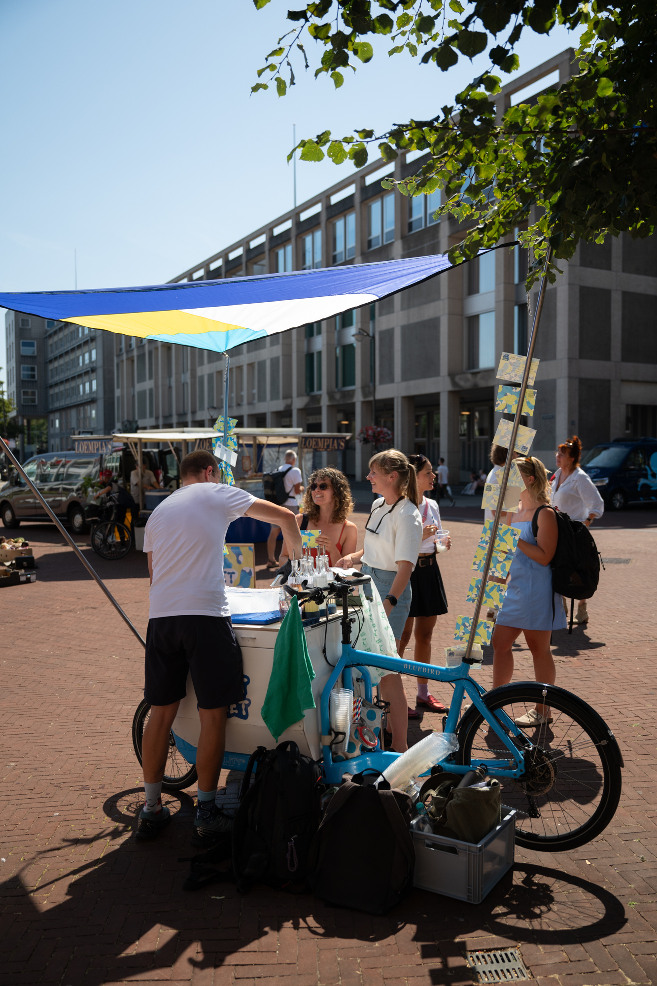 De kraam van Het Smeltloket onder een blauw-gele parasol