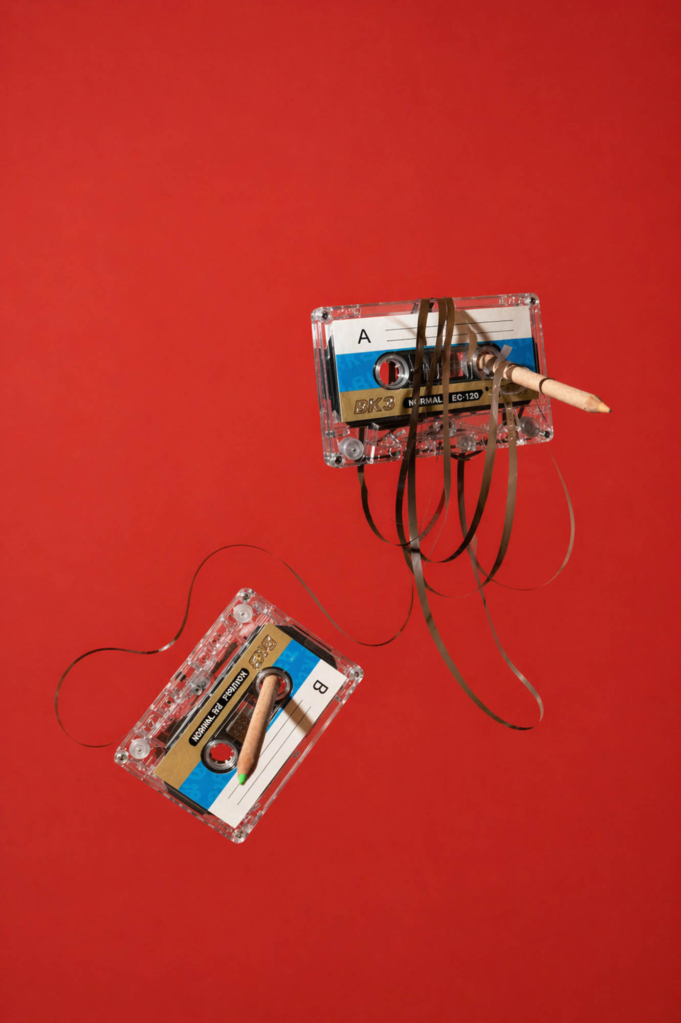 Cassettebandjes met potlood op rood