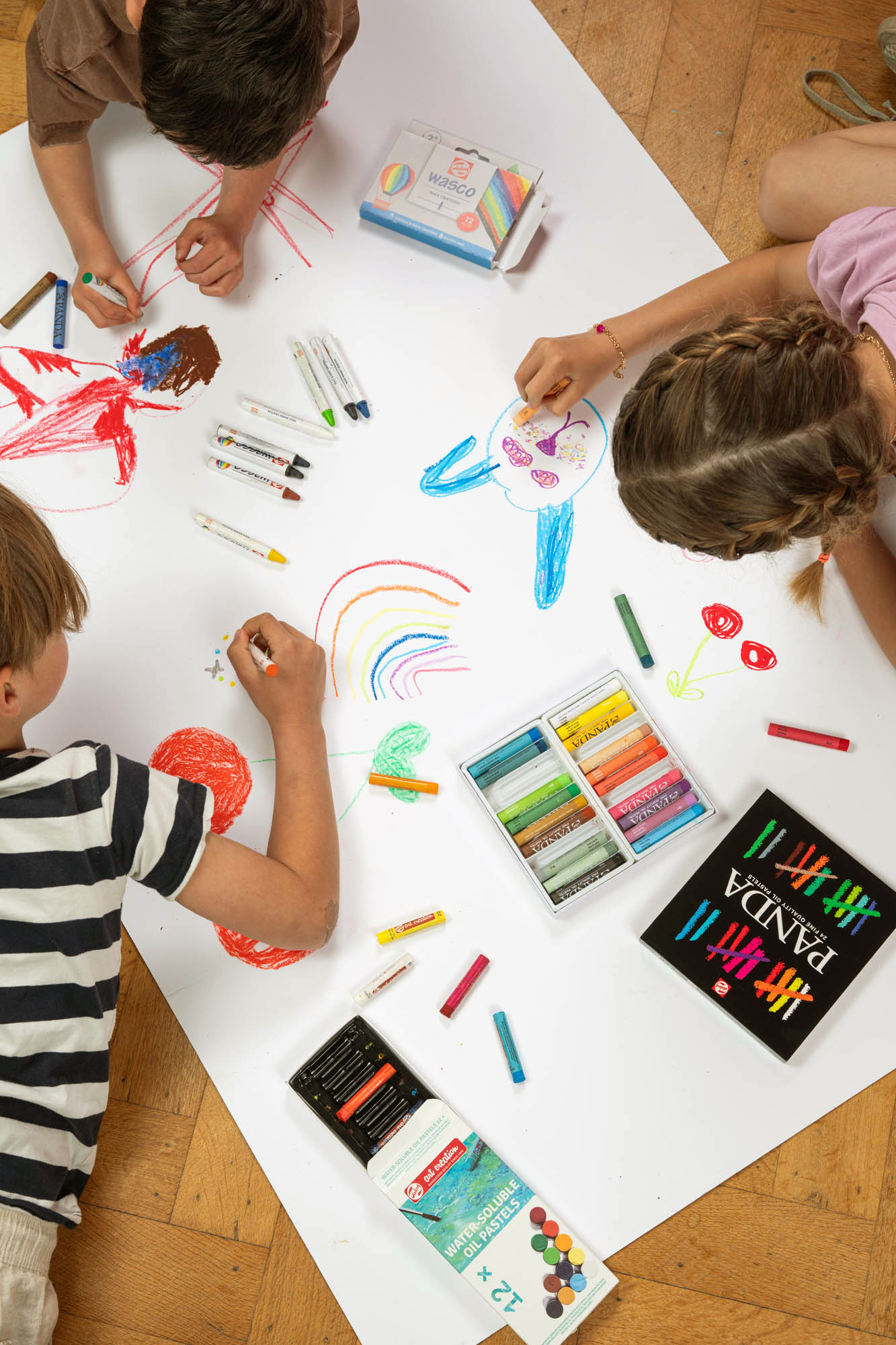 Kinderen tekenend op groot vel met Panda oliepastels